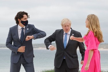Britain's Prime Minister Boris Johnson (C) and his wife Carrie Johnson welcome Canada's Prime Minister Justin Trudeau prior to the start of the G7 summit in Carbis Bay, Cornwall on June 11, 2021.