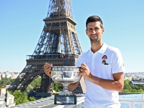Serbia's Novak Djokovic poses with the trophy in front of the Eiffel tower, on June 14, 2021 in Paris, during a photocall one day after winning the Roland Garros 2021 French Open tennis tournament.