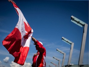 Ricky Johnson waves a Canadian flag on a hockey stick as he sings O Canada while attending Canada Day celebrations in Vancouver, on Monday July 1, 2019. This was the last time large-scale Canada Day celebrations were held in Vancouver.