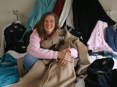 Sun columnist Shelley Fralic sits with some of her many coats, none of which she plans to give up.