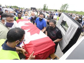 Pallbearers load a casket into a hearse after a funeral service for the four Muslim family members killed in a deadly vehicle attack.