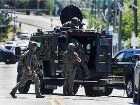 RCMP ERT members gather around an armoured vehicle on Westminster Highway between Gilley Road and McLean Avenue in Richmond, BC Tuesday, June 22, 2021.