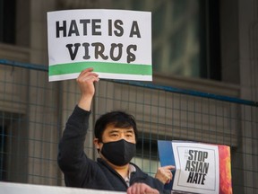 File photo of a man holding a sign at an anti-Asian hate rally in Vancouver in 2021.