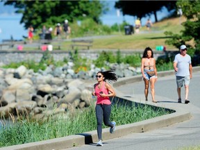 A jogger braves the heat near English Bay in Vancouver on Sunday amid record high temperatures.