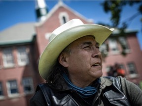 Kamloops Indian Residential School survivor Clayton Peters, 64, who was forced into the school for 10 years, sits on the lawn at the former school, in Kamloops, B.C., on Monday, May 31, 2021. Peters' parents and his brothers were also forced into the facility. The remains of 215 children have been discovered buried near the former school.