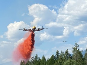 An airtanker makes a retardant drop on a fire burning near the Caithness Mobile Home Park, which was evacuated this afternoon after a wildfire broke out.