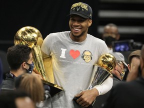 Giannis Antetokounmpo of the Milwaukee Bucks holds the Bill Russell NBA Finals MVP Award and the Larry O'Brien Championship Trophy after defeating the Phoenix Suns in Game Six to win the 2021 NBA Finals at Fiserv Forum on July 20, 2021 in Milwaukee.