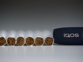 The Philip Morris International Inc. iQOS electronic cigarette, including Marlboro HeatSticks and iQOS holder, right, is arranged for a photograph in Tokyo, Japan, on Tuesday, Aug. 23, 2016. Philip Morris International and Japan Tobacco Inc. have rolled out products that are heated — not burned — in battery-charged devices, seeking to appeal to smokers who want their nicotine fix without the usual smell and smoke.