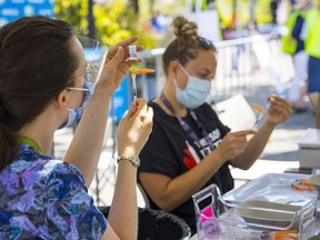 Nurses with Vancouver Coastal Health work at a vaccination pop-up at Playland as health officials push to increase the number of fully vaccinated adults in B.C.
