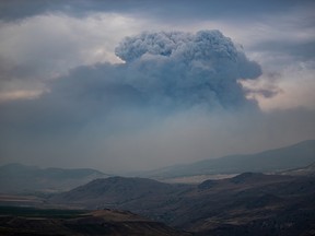 A pyrocumulus cloud, also known as a fire cloud, forms in the sky as the Tremont Creek wildfire burns on the mountains above Ashcroft on Friday, July 16, 2021.