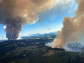 This handout photo courtesy of BC Wildfire Service shows two plumes of smoke from the Long Loch wildfire (K51040) and the Derrickson Lake wildfire (K51041), British Columbia, on June 30, 2021.