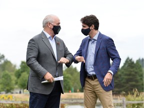 Canada's Prime Minister Justin Trudeau bumps elbows with B.C. Premier John Horgan at Town Centre Park in Coquitlam