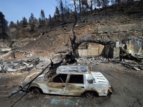 The charred remnants of a car, destroyed by a wildfire on June 30, is seen during a media tour by authorities in Lytton, July 9, 2021.