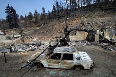 The charred remnants of a car, destroyed by a wildfire on June 30, is seen during a media tour by authorities in Lytton, British Columbia, Canada July 9, 2021.  REUTERS/Jennifer Gauthier