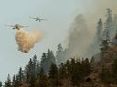 Water bombers designed to scoop water from nearby lakes douse part of the Nk'Mip Creek wildfire near Osoyoos on July 20, 2021.