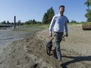 Vancouver County Michael Wiebe is building a trail that runs along the north side of the Fraser River. The trail is currently blocked at Marine Drive Golf Club, but Weave hopes a solution can be found. Weave is posing for a photo with his dog K'La on the beach under the high tide mark below the golf course.