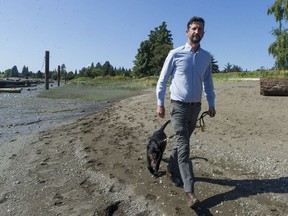 Vancouver Coun. Michael Wiebe is trying to create a trail that runs along the north side of the Fraser River. The trail currently is blocked at the Marine Drive Golf Club, but Wiebe is hoping a solution can be found. Wiebe is pictured with his dog K'La on the beach below the high-tide mark below the golf course, and where Wiebe hopes the trail will one day run.