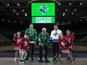 Handout photo of Francesco Aquilini (left), Abbotsford Mayor Henry Braun (middle), and Jim Benning surrounded by kids at announcement for the new Vancouver Canucks farm team named Abbotsford Canucks.