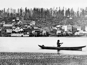 A photo circa 1866 of a First Nations man paddling his canoe past the fledgling Fraser River community of New Westminister. From "Photographic History of New Westminster 1858," by Jim Wolf.