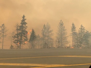 Smoke is seen as trees burn along a street during a wildfire in Lytton, British Columbia, Canada June 30, 2021 in this still image obtained from a social media video on July 1, 2021. 2 RIVERS REMIX SOCIETY/via REUTERS THIS IMAGE HAS BEEN SUPPLIED BY A THIRD PARTY. MANDATORY CREDIT. NO RESALES. NO ARCHIVES. MUST CREDIT "2 RIVERS REMIX SOCIETY / VIMEO.2RMX.CA".