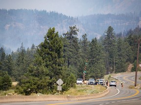 RCMP officers block the Trans-Canada Highway as wildfire burns in Lytton, B.C., on Friday, July 2, 2021.