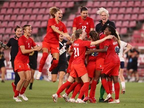 Teammates rush Jessie Fleming (17) after her 74th-minute penalty kick went in. The goal would be enough for the Canadians to beat the Americans for the first time in 20 years, and to advance to the gold-medal game against Sweden.
