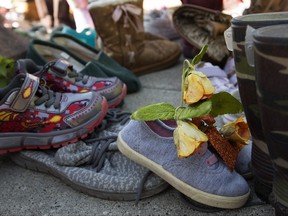 Children's shoes have been placed around the Emily Murphy statue in Edmonton's Emily Murphy Park, Friday Aug. 13, 2021.