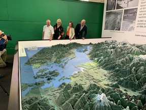 The Challenger Relief Map is coming back to the Pacific National Exhibition after 23 years. Here, from left, Bill Challenger, PNE president Shelley Frost and Vancouver councillors Lisa Dominato and Pete Fry check out a restored portion of the map Aug. 19. The red line is the border between Canada and the U.S.
