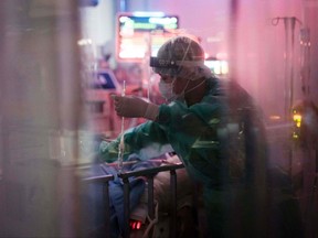 A medical worker takes care of a coronavirus patient on a mechanical ventilator in a negative-pressure room surrounded by plastic curtains in the ICU at St. Marianna University School of Medicine Yokohama City Seibu Hospital.