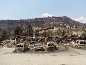The charred remnants of vehicles, destroyed by a wildfire on June 30, are seen during a media tour by authorities in Lytton, B.C.