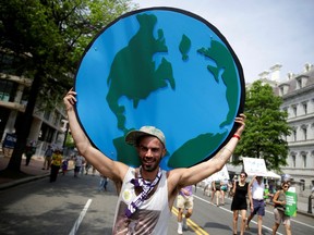 FILE PHOTO: A protester carries a sign depicting the earth during the Peoples Climate March near the White House in Washington, U.S., April 29, 2017.