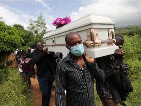 People carry a coffin during a funeral after the earthquake that took place on August 14th, in Marceline near Les Cayes, Haiti, Aug. 21, 2021.