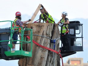 A work crew dismantles the Trans Am Totem in False Creek on Saturday. The public art work is being restored and then relocated to a yet-to-be determined site.