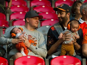 A couple of fans and their babies enjoy the return of the CFL at B.C. Place on Thursday as the B.C. Lions lost their home opener to the Edmonton Elks.