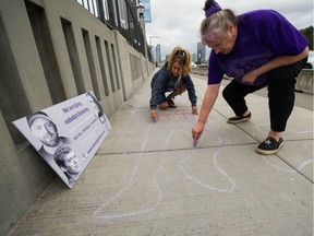 Deb Bailey (right) and Sharene Shuster on Burrard Street Bridge in Vancouver on Monday. The group Moms Stop The Harm was again drawing attention to the overdose crisis by drawing dead-body outlines on the bridge.