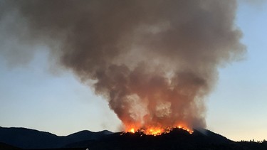 Skaha Creek fire crested over ridge near Penticton early Monday morning.