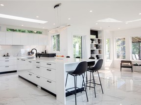 A marble block serves as a bar and focal point in the kitchen, concealing prep mess from diners. A wok kitchen is concealed behind cabinetry with a hidden door mechanism.