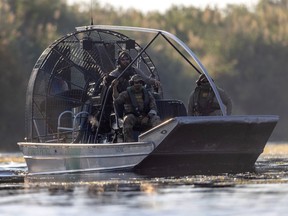 U.S. Border Patrol agents watch as Haitian immigrants cross the Rio Grande back into Mexico from Del Rio, Texas on September 20, 2021 to Ciudad Acuna, Mexico.