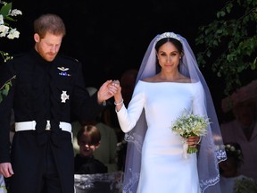 Britain's Prince Harry, Duke of Sussex and his wife Meghan, Duchess of Sussex leave from the West Door of St George's Chapel, Windsor Castle, in Windsor on May 19, 2018 in Windsor, England.