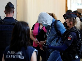 French gendarmes escort one unidentified accused as he arrives on the second day of the trial of the Paris' November 2015 attacks at the Paris courthouse on the Ile de la Cite, in Paris, France, September 9, 2021.