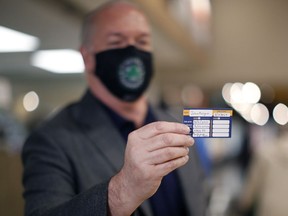 Premier John Horgan shows his vaccination card after receiving a dose of the AstraZeneca COVID-19 vaccine at the pharmacy in James Bay Thrifty's Foods in Victoria on Friday, April 16, 2021.