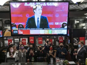 Liberal Party of Canada supporters gather around a TV in Vancouver to watch Prime Minister Justin Trudeau speak after winning a minority government.