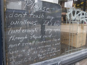 A sign in the window of Finch's Tea and Coffee House on West Pender Street in Vancouver asks people to not break their windows.