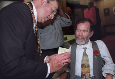 1999. Mayor Philip Owen presents new councillor Tim Louis with a pin at the new city councils inaugural meeting.