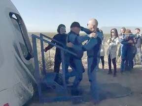 William Shatner (CL) gets a hug from Blue Origin founder Jeff Bezos on October 13, 2021, after landing in the West Texas region, 25 miles (40kms) north of Van Horn.