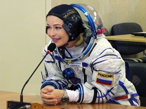 This handout photo taken and released on October 5, 2021 by Russian Space Agency Roscosmos shows crew member actress Yulia Peresild reacting as her spacesuits is tested prior to the launch onboard the Soyuz MS-19 spacecraft at the Russian-leased Baikonur cosmodrome.