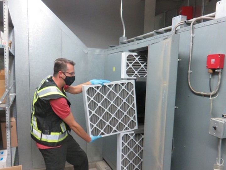  Sam Caskey swaps out a filter in a HVAC system at a Surrey school in 2020.