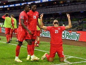 Canada's Jonathan Osorio (right) celebrates after scoring against Mexico during their Qatar 2022 FIFA World Cup Concacaf qualifier match at the Azteca Stadium, in Mexico City, on Oct. 7, 2021.