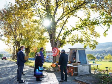 In this photo provided by the Office of the Prime Minister of Canada, Canadian Prime Minister Justin Trudeau (2R) and Minister of Indigenous Services of Canada Marc Miller (L) lay flowers at a memorial outside of the Kamloops Indian Residential School in Kamloops, B.C., on Oct. 18, 2021.