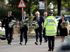 Chief Constable of Essex Police B. J. Harrington, Britain's Labour Party leader Keir Starmer, Prime Minister Boris Johnson, Speaker of the House Sir Lindsay Hoyle and Home Secretary Priti Patel hold flowers as they arrive at the scene where British MP David Amess was stabbed to death during a meeting with constituents.